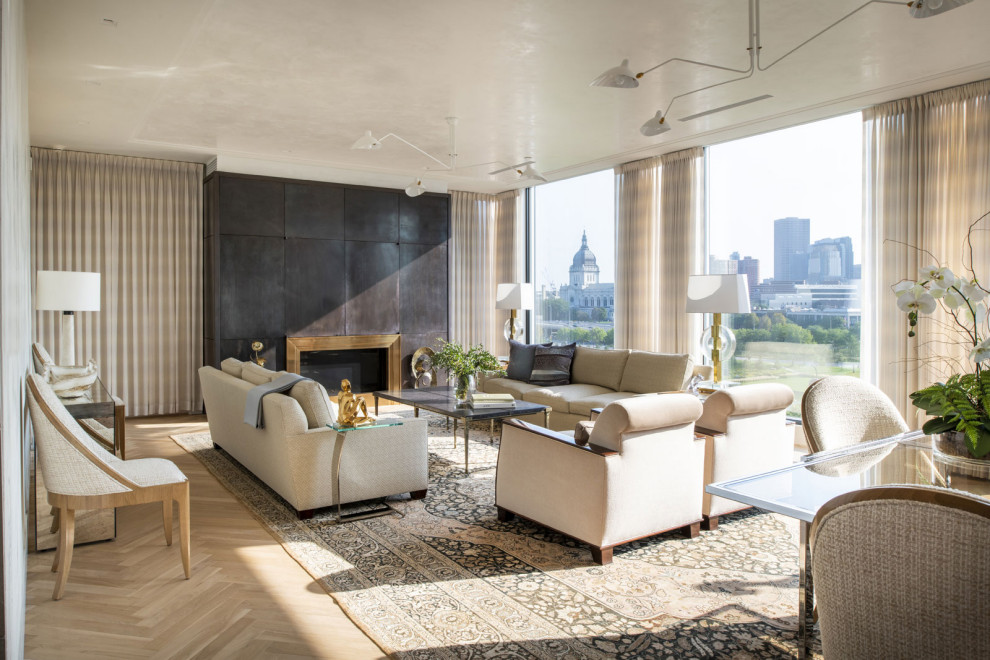 Modernes Wohnzimmer mit hellem Holzboden, Kamin, Kaminumrandung aus Metall und verstecktem TV in Minneapolis