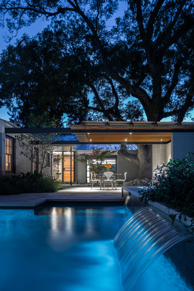 Photo of a contemporary pool in Austin with a water feature.