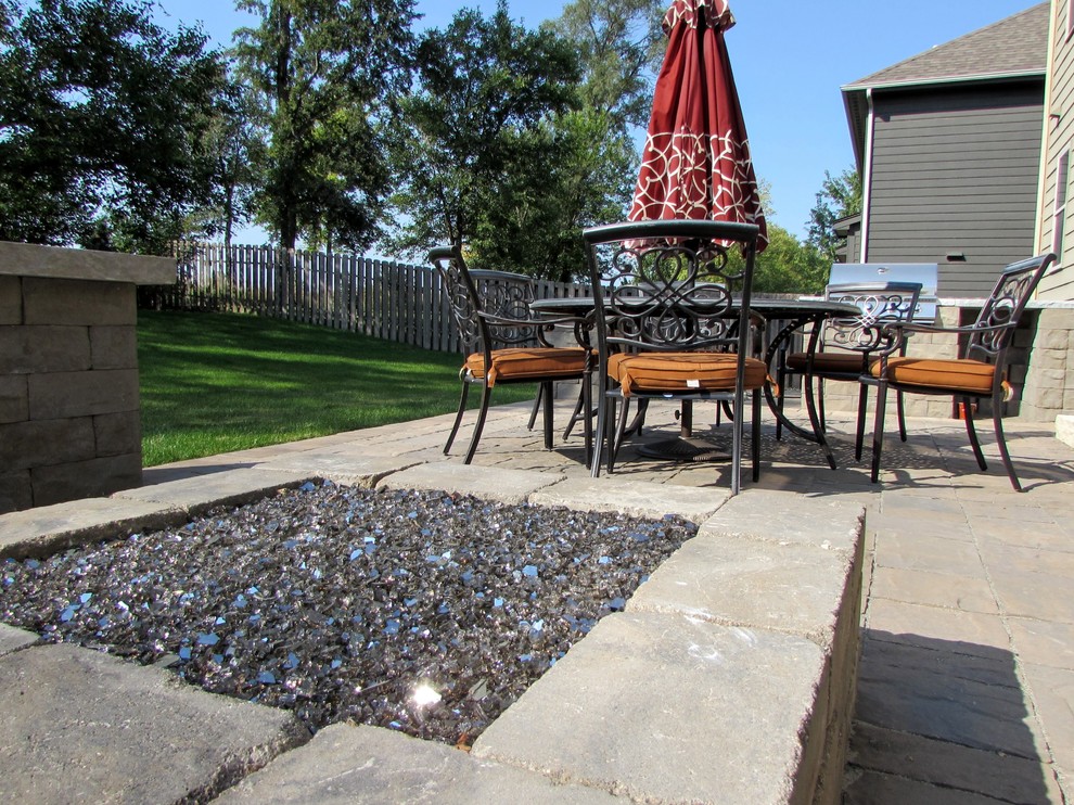 Photo of a large traditional backyard patio in Other with a fire feature, natural stone pavers and no cover.