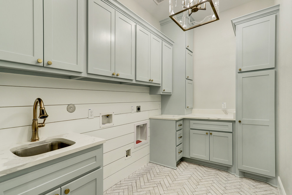 This is an example of a transitional laundry room in Houston with a single-bowl sink, raised-panel cabinets, grey cabinets, marble benchtops, white splashback, shiplap splashback, white walls, ceramic floors, white floor and white benchtop.
