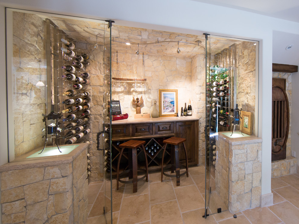 Mediterranean wine cellar in Orange County with display racks and beige floor.