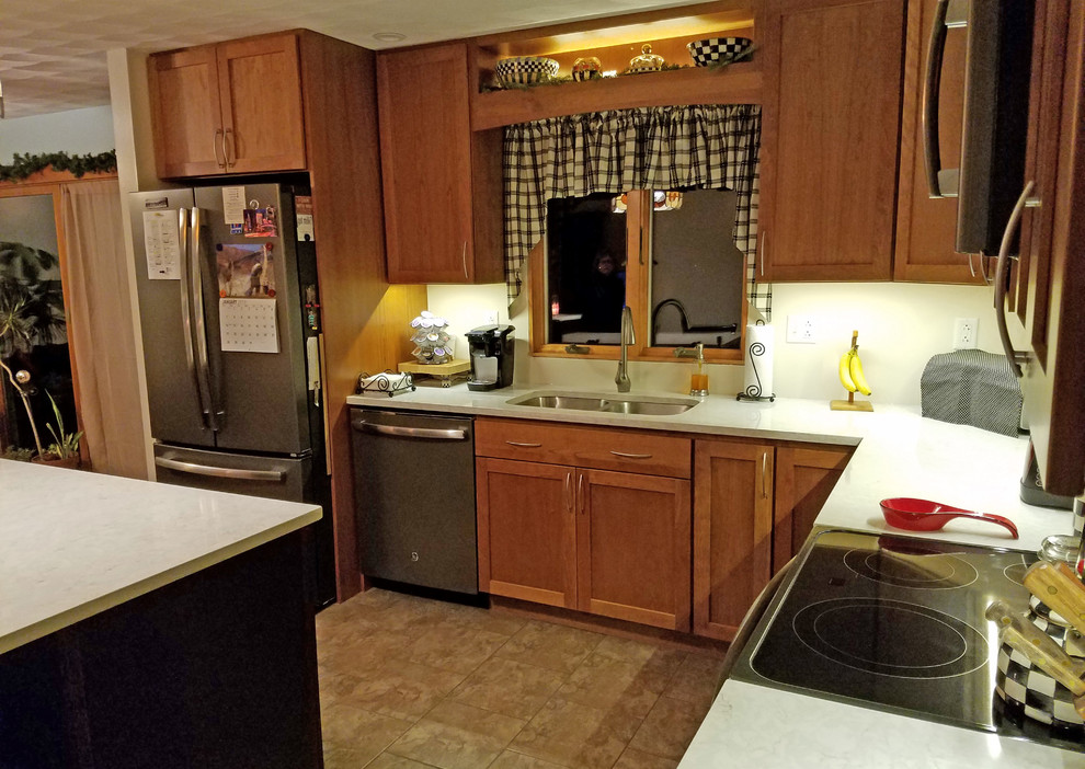 Example of a mid-sized transitional l-shaped ceramic tile and yellow floor eat-in kitchen design with an undermount sink, shaker cabinets, medium tone wood cabinets, quartz countertops, stainless steel appliances, an island and white countertops