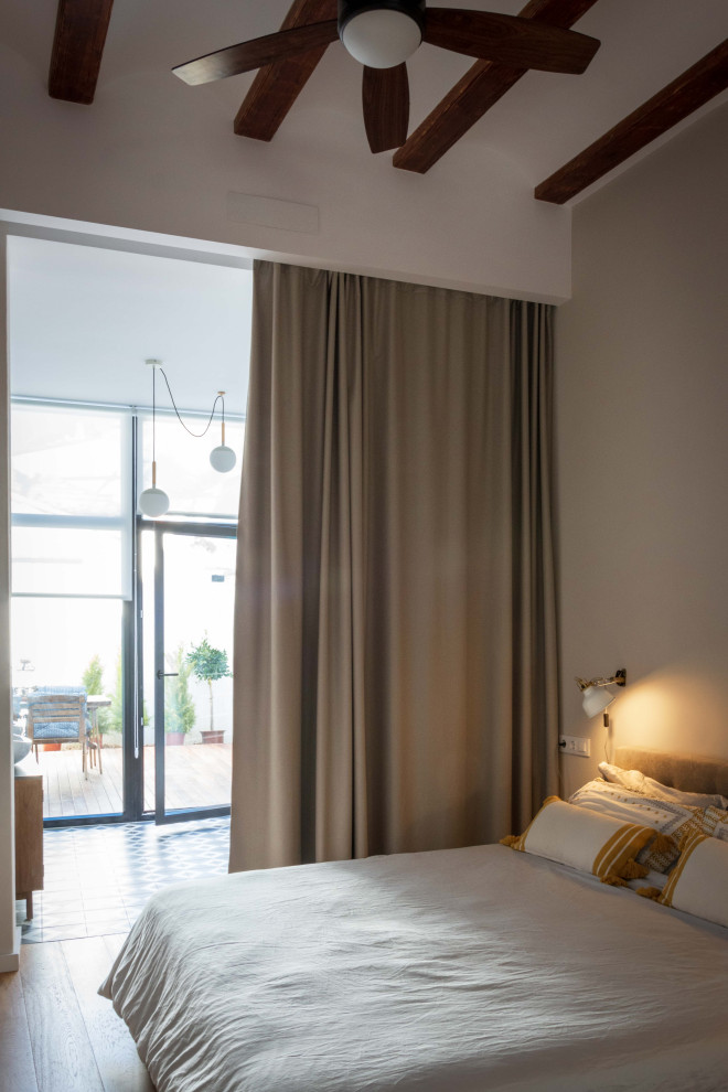 Design ideas for a mid-sized mediterranean master bedroom in Valencia with medium hardwood floors.
