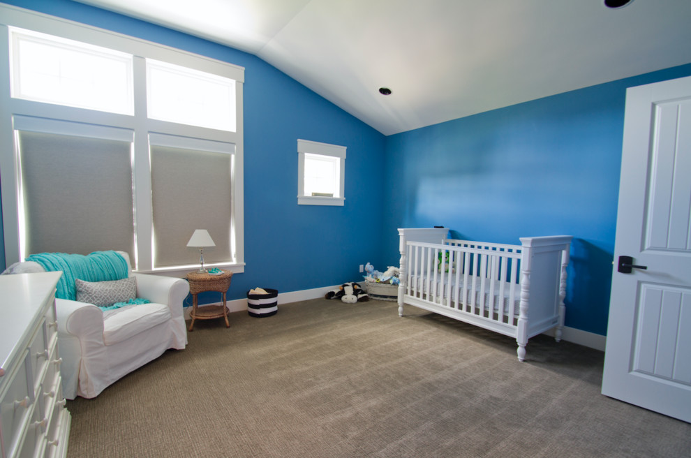 This is an example of a large transitional gender-neutral nursery in Seattle with blue walls, carpet and brown floor.