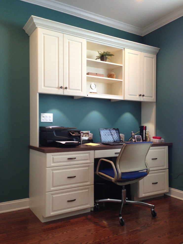 Inspiration for a mid-sized traditional study room in New York with blue walls, dark hardwood floors, no fireplace, a built-in desk and brown floor.