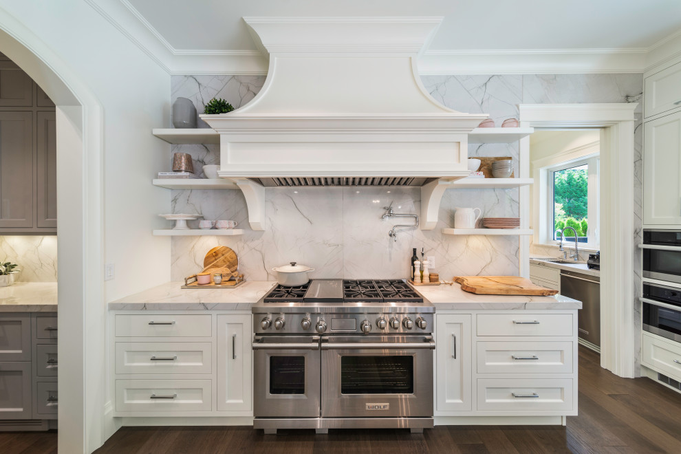 Design ideas for a large transitional eat-in kitchen in Vancouver with flat-panel cabinets, white cabinets, marble benchtops, white splashback, marble splashback, stainless steel appliances, dark hardwood floors, with island, brown floor and white benchtop.