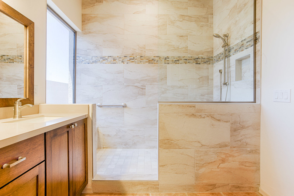 Large transitional master gray tile and porcelain tile doorless shower photo in Phoenix with recessed-panel cabinets, medium tone wood cabinets, beige walls, an undermount sink and quartzite countertops
