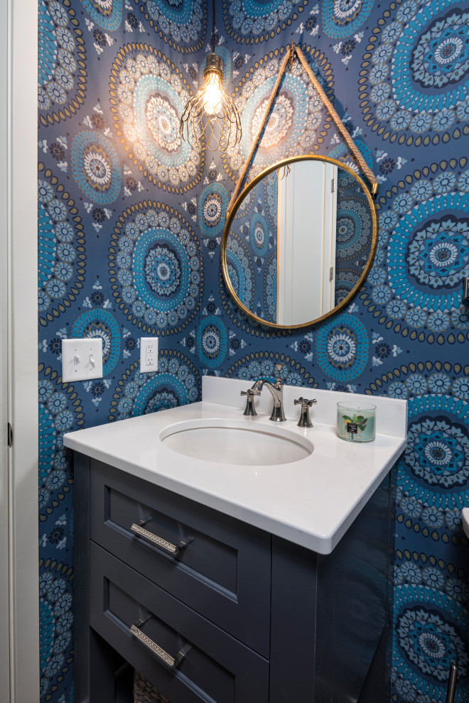 Photo of a small beach style bathroom in Minneapolis with flat-panel cabinets, blue cabinets, blue walls, medium hardwood floors, an undermount sink, engineered quartz benchtops and white benchtops.