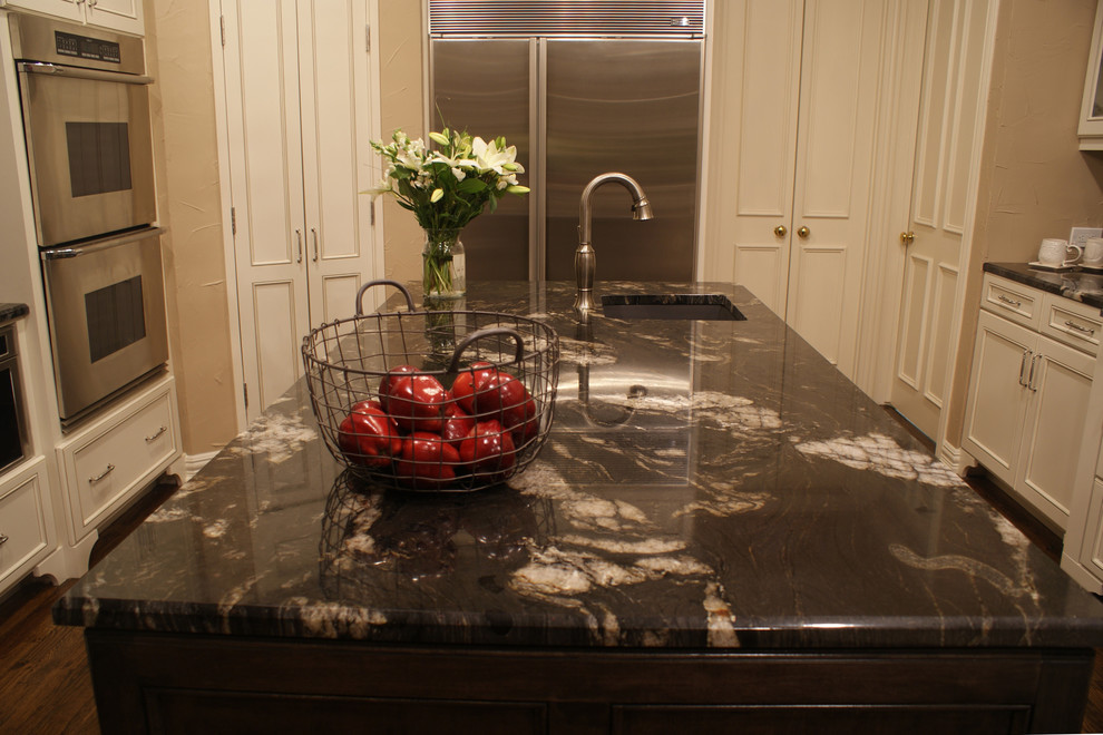 Example of a large transitional medium tone wood floor kitchen design in Dallas with an undermount sink, flat-panel cabinets, white cabinets, granite countertops, ceramic backsplash, stainless steel appliances, beige walls and an island