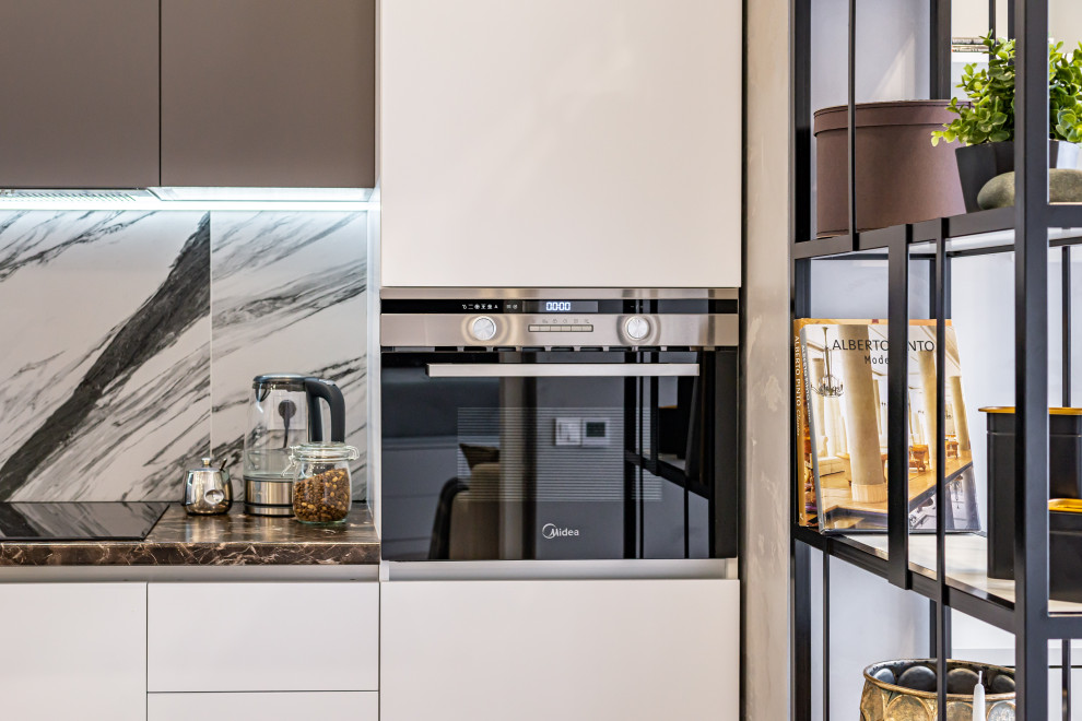 На фото: прямая, глянцевая, серо-белая кухня-гостиная среднего размера в скандинавском стиле с плоскими фасадами, полом из керамогранита и черным полом