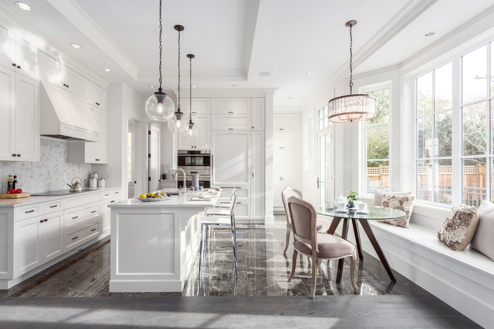Design ideas for a transitional kitchen in Vancouver with recessed-panel cabinets, white cabinets, grey splashback, panelled appliances, with island and grey floor.
