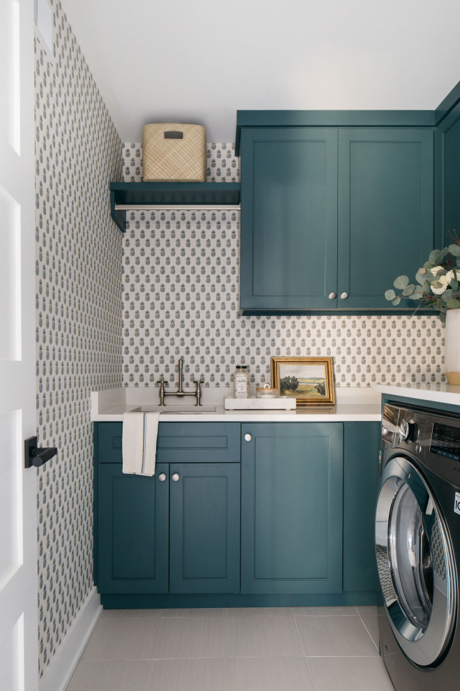 Photo of a medium sized rural l-shaped utility room in Chicago with a submerged sink, shaker cabinets, turquoise cabinets, a side by side washer and dryer, beige floors, white worktops and wallpapered walls.