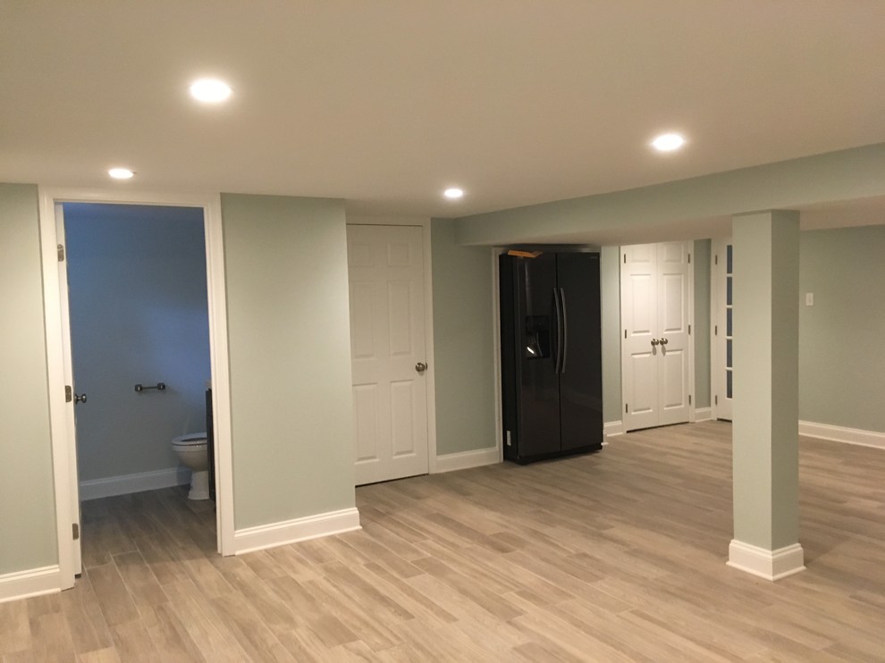 Photo of an expansive contemporary basement in Philadelphia with green walls, ceramic floors and grey floor.