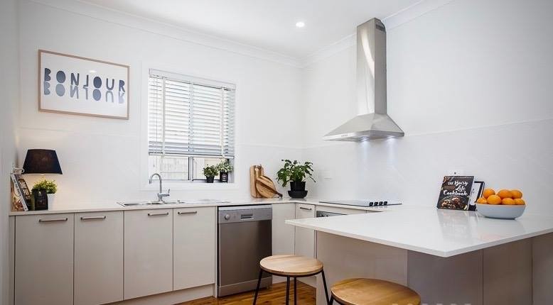 Inspiration for a small scandinavian u-shaped eat-in kitchen in Newcastle - Maitland with a drop-in sink, beige cabinets, quartzite benchtops, white splashback, subway tile splashback, stainless steel appliances, light hardwood floors, with island and brown floor.