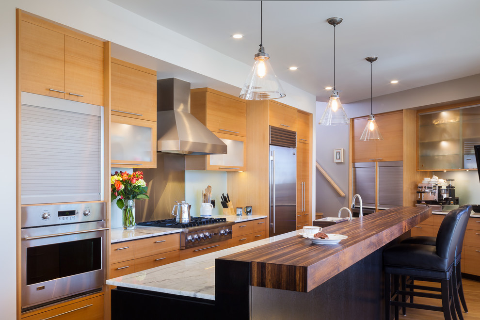 Design ideas for a large contemporary galley open plan kitchen in Los Angeles with an undermount sink, flat-panel cabinets, medium wood cabinets, quartzite benchtops, glass sheet splashback, stainless steel appliances, medium hardwood floors and with island.
