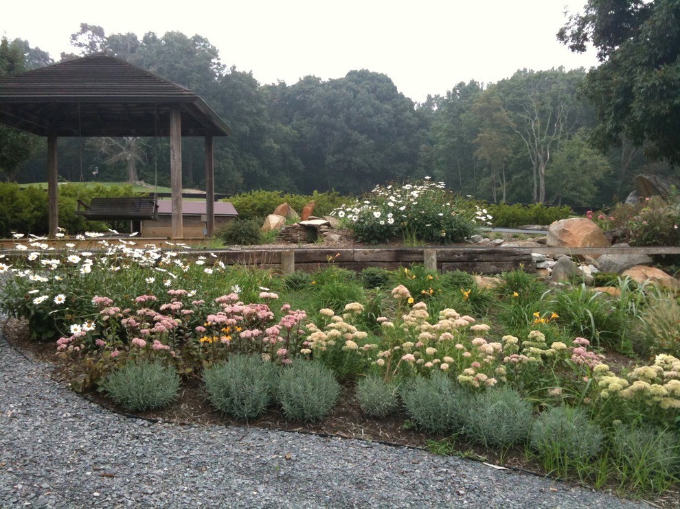 Inspiration for a large rustic partial sun backyard stone formal garden for summer.
