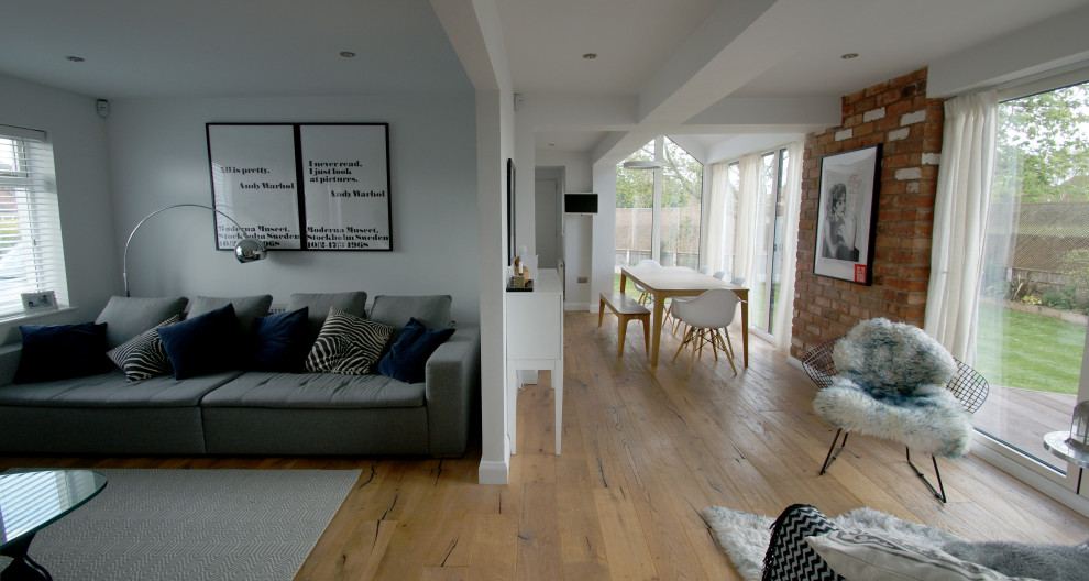 Idee per un grande soggiorno nordico aperto con pavimento in legno massello medio