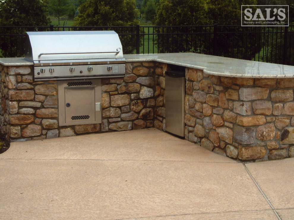 Mid-sized traditional backyard patio in Philadelphia with an outdoor kitchen, concrete slab and no cover.