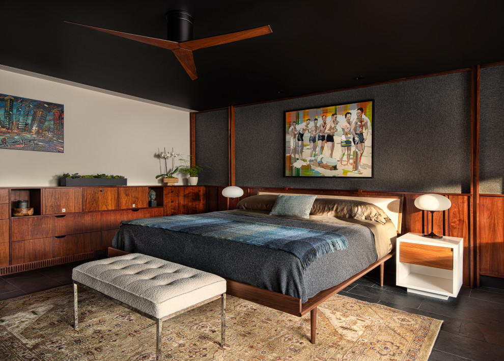 На фото: большая хозяйская спальня в стиле ретро с разноцветными стенами, полом из сланца, черным полом и панелями на части стены с