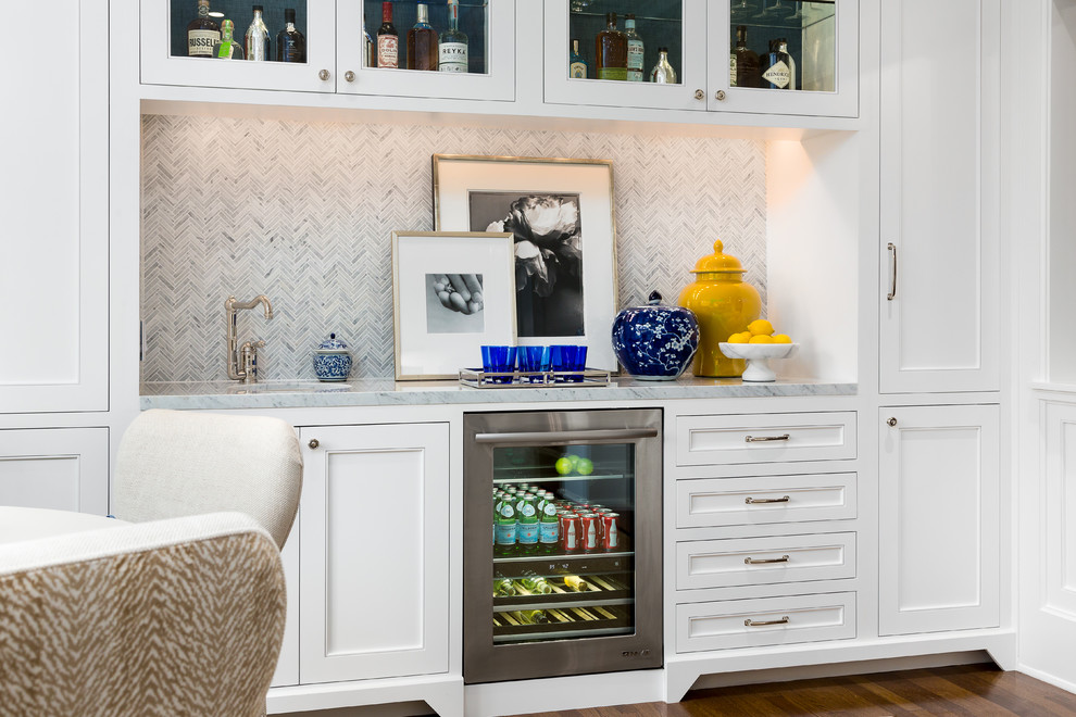 Inspiration for a mid-sized transitional single-wall wet bar in Los Angeles with an undermount sink, beaded inset cabinets, white cabinets, marble benchtops, grey splashback, mosaic tile splashback and dark hardwood floors.