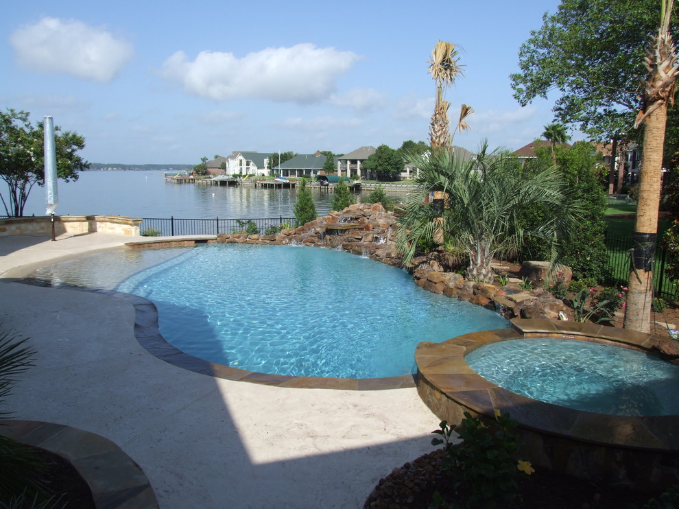 Inspiration for a tropical side yard custom-shaped natural pool in Houston with stamped concrete.