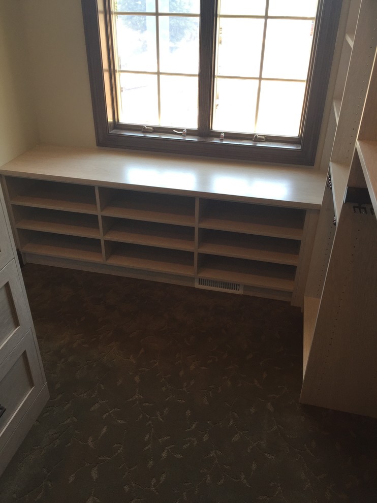 Design ideas for an expansive transitional gender-neutral walk-in wardrobe in Minneapolis with shaker cabinets, light wood cabinets, carpet and brown floor.