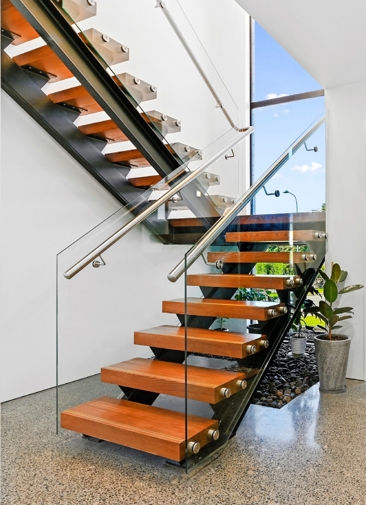 Large modern wood floating metal railing staircase in Christchurch with open risers.