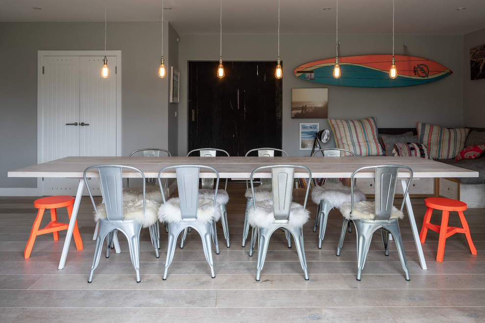 Design ideas for a large beach style separate dining room in Sussex with grey walls and light hardwood floors.