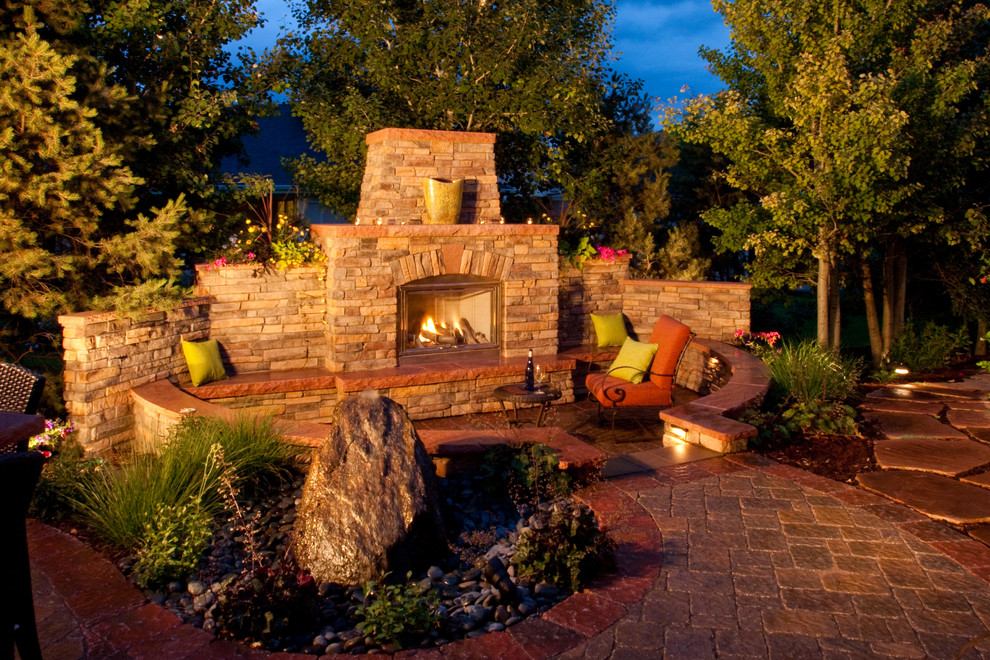 Large traditional backyard patio in Denver with a fire feature and concrete pavers.
