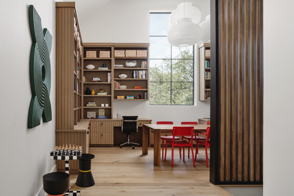Trendy gender-neutral light wood floor and beige floor kids' room photo in Other with white walls