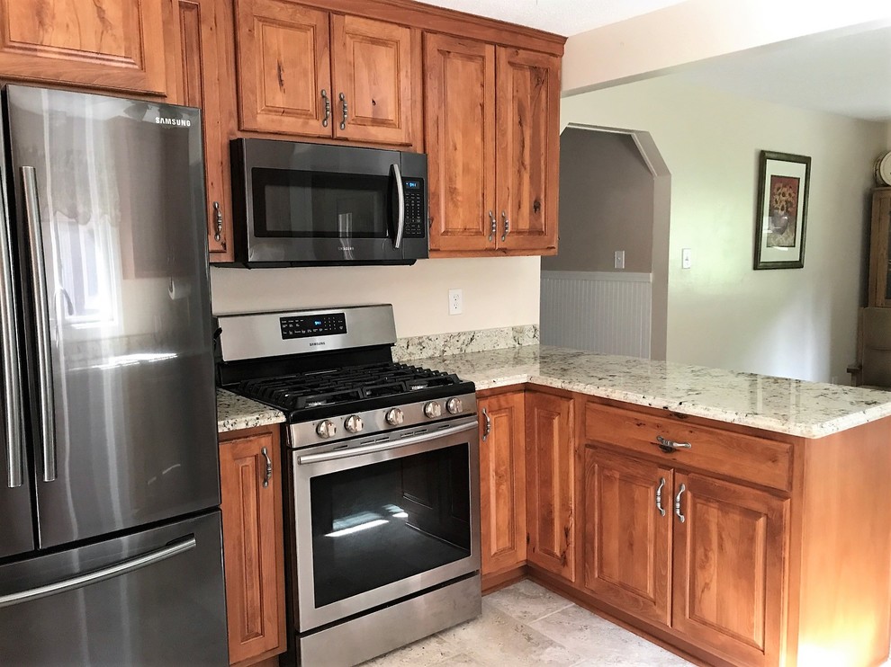 Inspiration for a small transitional eat-in kitchen remodel with raised-panel cabinets, medium tone wood cabinets, granite countertops and a peninsula