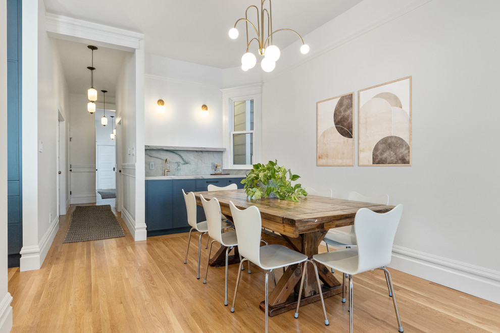 Idée de décoration pour une grande salle à manger ouverte sur la cuisine victorienne avec un mur blanc, un sol en bois brun et un sol marron.