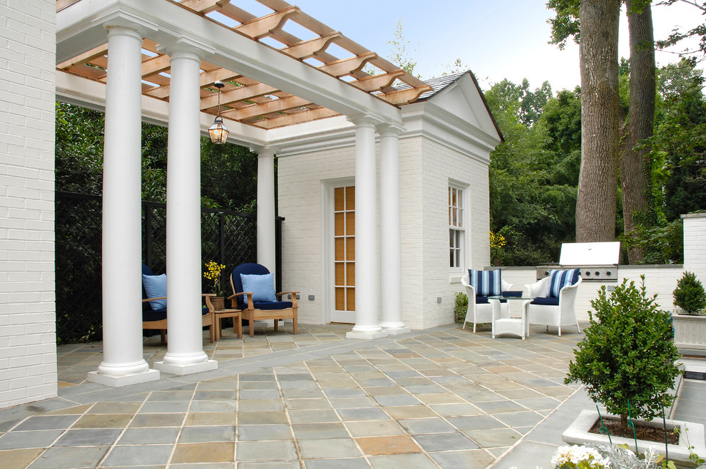 Photo of a traditional backyard patio in DC Metro with a pergola and natural stone pavers.