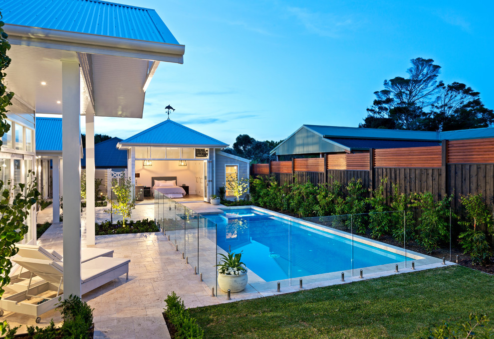 This is an example of a large beach style backyard rectangular pool in Melbourne with natural stone pavers.