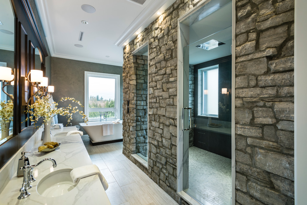 This is an example of an expansive country master wet room bathroom in Vancouver with shaker cabinets, dark wood cabinets, a freestanding tub, a two-piece toilet, gray tile, stone tile, grey walls, porcelain floors, an undermount sink, solid surface benchtops, grey floor, a hinged shower door and white benchtops.