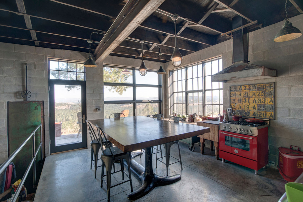 Industrial kitchen/dining combo in Seattle with concrete floors.