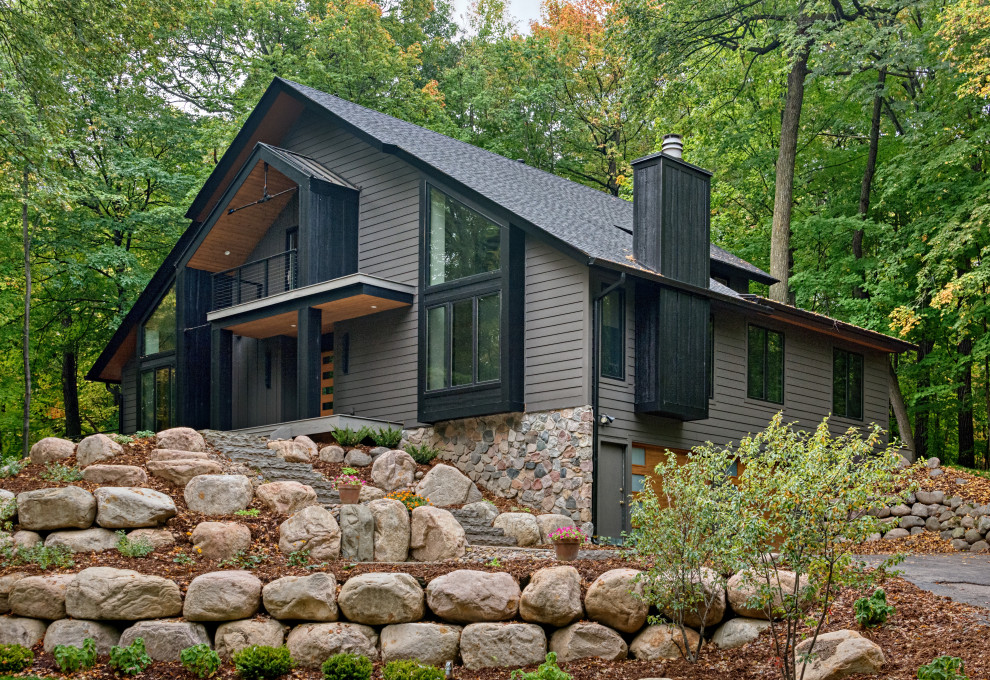 Idée de décoration pour une très grande façade de maison grise nordique à un étage avec un revêtement mixte, un toit à deux pans, un toit mixte et un toit noir.