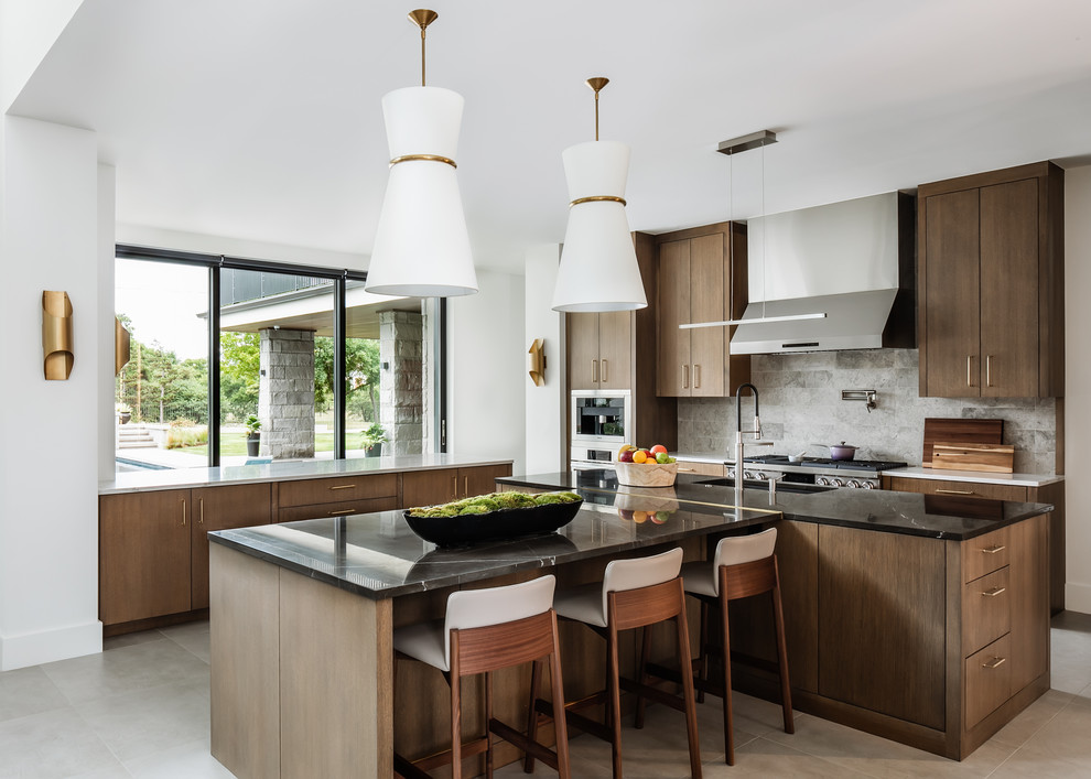 Inspiration for a contemporary l-shaped kitchen in Oklahoma City with an undermount sink, flat-panel cabinets, dark wood cabinets, grey splashback, stainless steel appliances, multiple islands, grey floor and black benchtop.