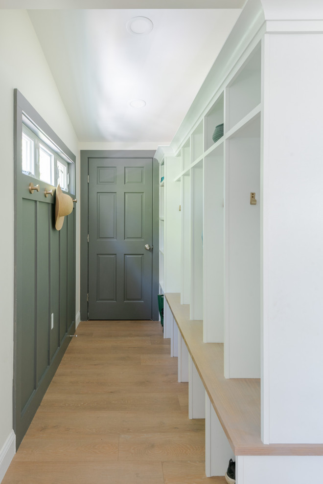 Small transitional light wood floor, brown floor and wall paneling mudroom photo in Boston with gray walls