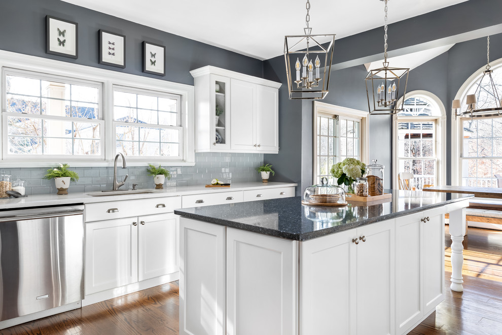 Inspiration for a huge transitional l-shaped dark wood floor and brown floor eat-in kitchen remodel in Philadelphia with a single-bowl sink, flat-panel cabinets, white cabinets, quartzite countertops, gray backsplash, ceramic backsplash, stainless steel appliances, an island and white countertops