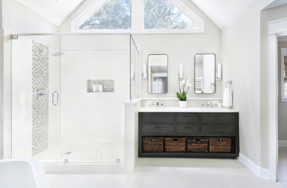 Photo of a large transitional bathroom in Atlanta with flat-panel cabinets, black cabinets, a freestanding tub, an alcove shower, beige walls, an undermount sink, beige floor, a hinged shower door and white benchtops.