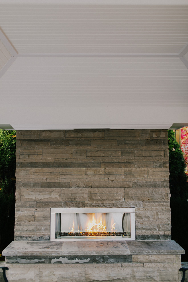 Design ideas for a mid-sized arts and crafts backyard patio in Toronto with a fire feature.