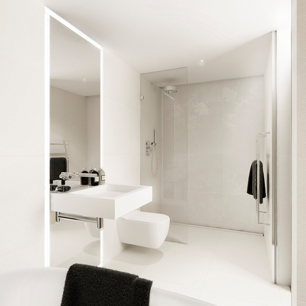 This is an example of a large modern kids bathroom in London with a freestanding tub, a wall-mount toilet, beige tile, white tile, beige walls, ceramic floors, a wall-mount sink, an open shower, a curbless shower and white floor.