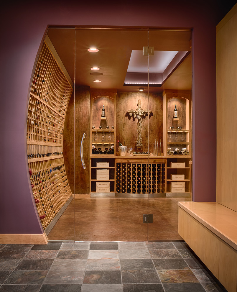 Transitional wine cellar in Minneapolis with concrete floors, display racks and brown floor.