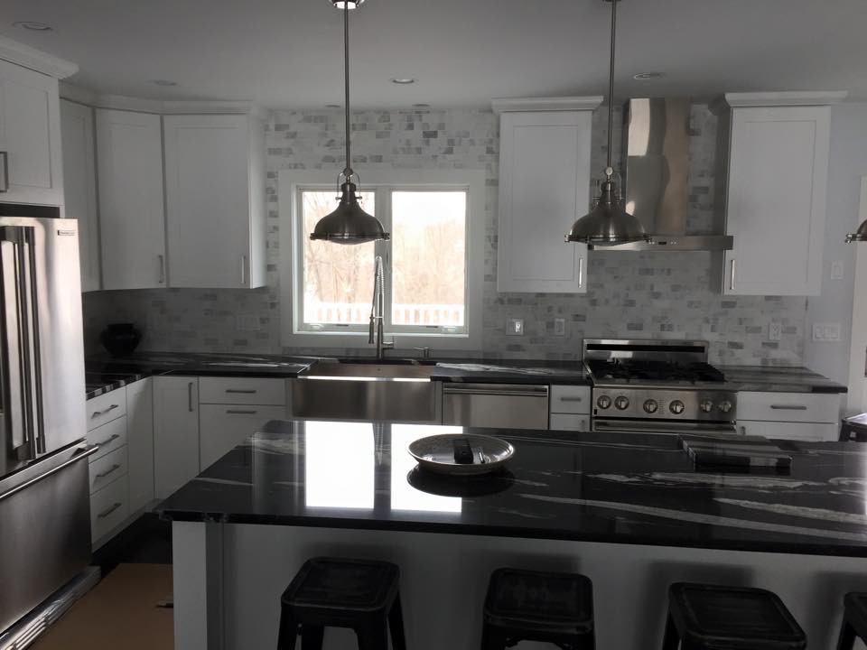 Mid-sized modern l-shaped separate kitchen in Boston with a farmhouse sink, shaker cabinets, white cabinets, granite benchtops, multi-coloured splashback, porcelain splashback, stainless steel appliances, dark hardwood floors and with island.
