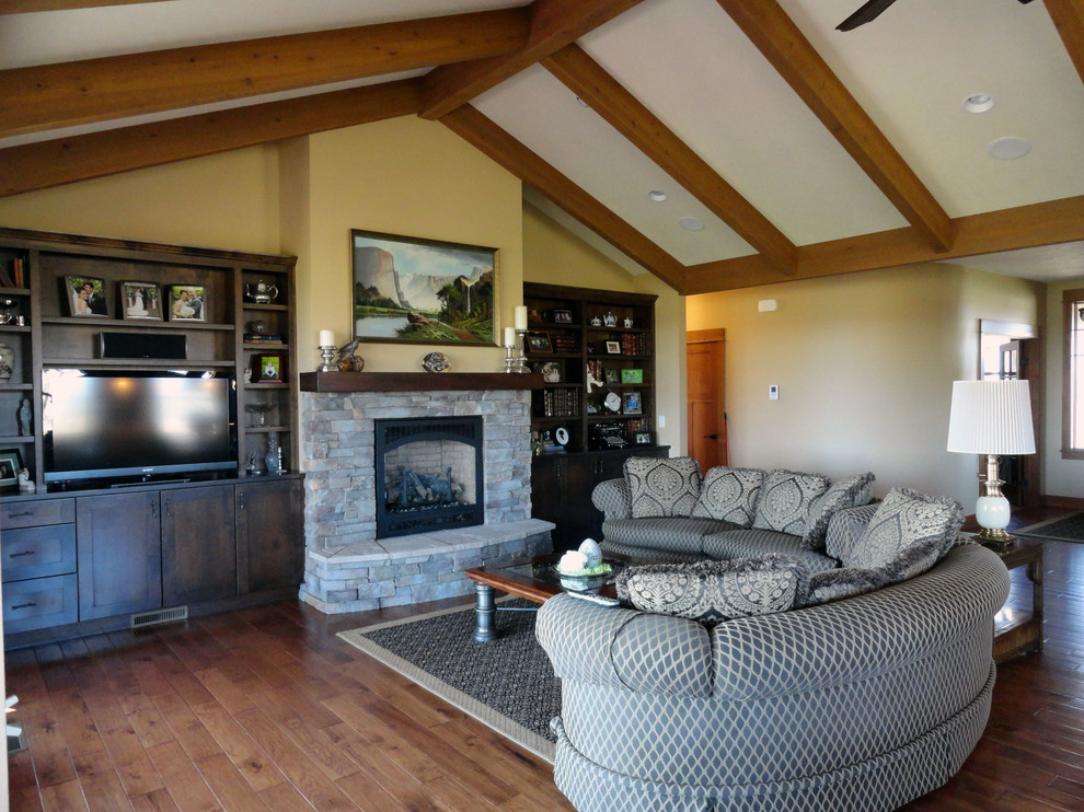 Photo of a large arts and crafts open concept family room in Seattle with beige walls, medium hardwood floors, a standard fireplace, a stone fireplace surround and a built-in media wall.