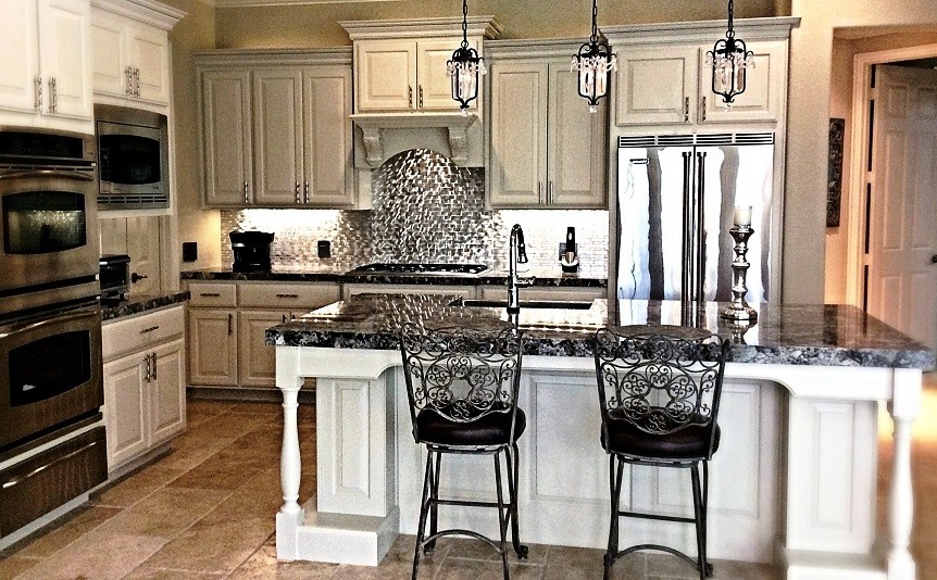 Mid-sized transitional l-shaped travertine floor eat-in kitchen photo in Houston with a farmhouse sink, raised-panel cabinets, white cabinets, granite countertops, metallic backsplash, metal backsplash, stainless steel appliances and an island