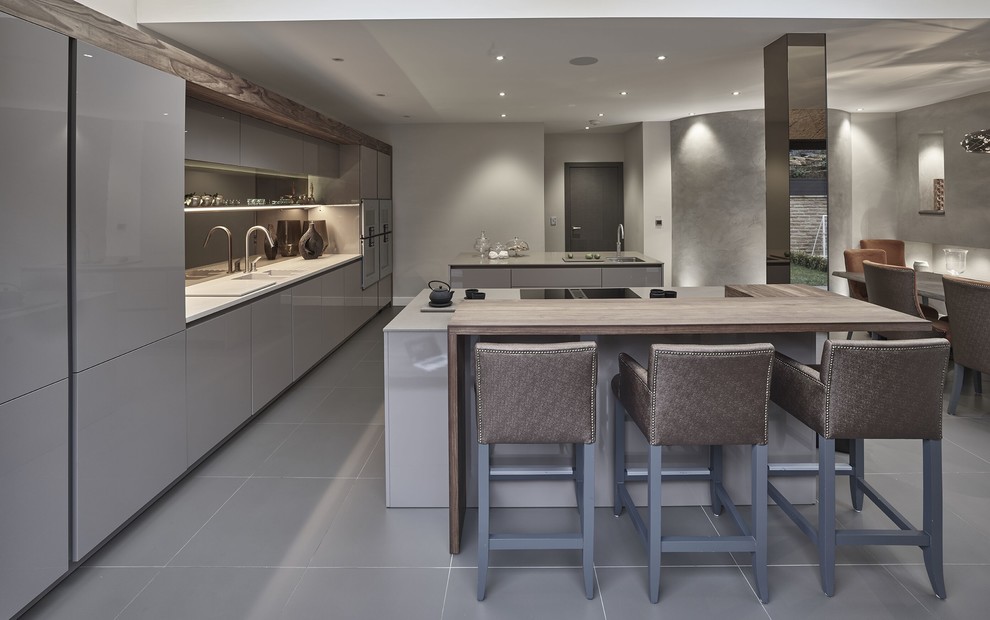 Design ideas for a large contemporary single-wall eat-in kitchen in Other with a drop-in sink, flat-panel cabinets, beige cabinets, quartzite benchtops, brown splashback, mirror splashback, stainless steel appliances, porcelain floors, multiple islands and grey floor.