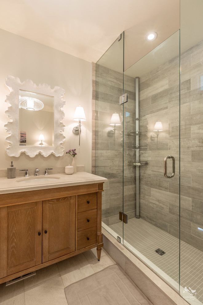 Design ideas for a mid-sized transitional 3/4 bathroom in Toronto with shaker cabinets, distressed cabinets, a corner shower, a two-piece toilet, gray tile, porcelain tile, grey walls, porcelain floors, an undermount sink, engineered quartz benchtops, beige floor and a hinged shower door.