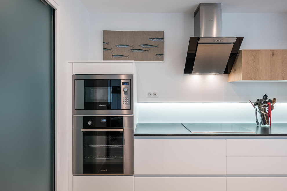 Design ideas for a large contemporary galley kitchen in Lyon with a single-bowl sink, white cabinets, granite benchtops, white splashback, glass sheet splashback, stainless steel appliances, ceramic floors and no island.